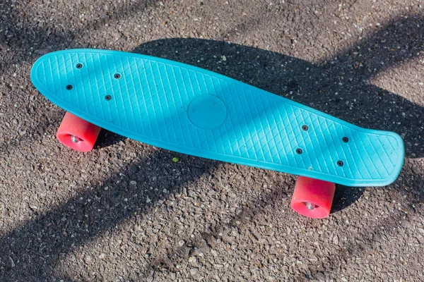 Blaues Penny Board mit rosa Rädern. — Stockfoto