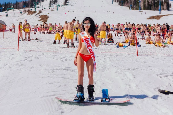 Unga glada vackra kvinnor på en snowboard i färgglada bikini. — Stockfoto