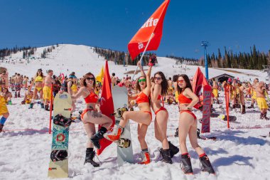 Grup genç mutlu güzel kadını bayrakları ile renkli bikini bir snowboard üzerinde.