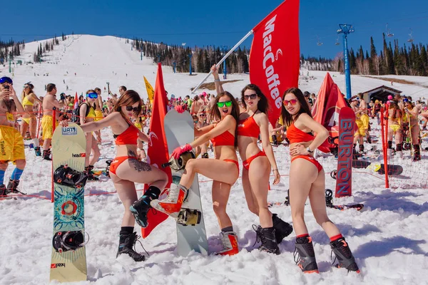 Grup genç mutlu güzel kadını bayrakları ile renkli bikini bir snowboard üzerinde.