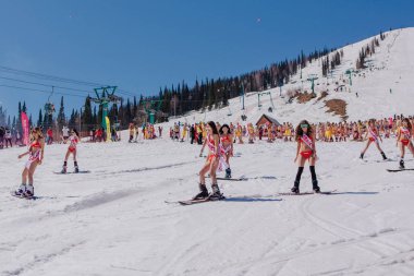 Grup genç mutlu güzel kadını bayrakları ile renkli bikini bir snowboard üzerinde.