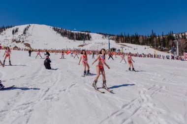 Grup genç mutlu güzel kadını bayrakları ile renkli bikini bir snowboard üzerinde.