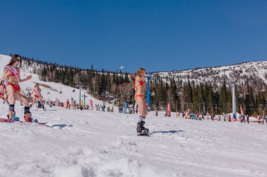 Grup genç mutlu güzel kadını bayrakları ile renkli bikini bir snowboard üzerinde.