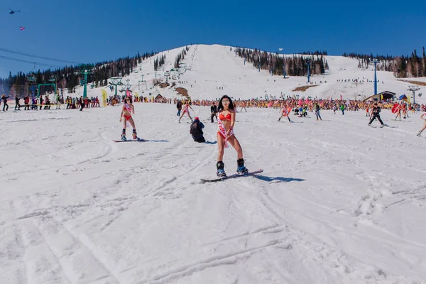 Grup genç mutlu güzel kadını bayrakları ile renkli bikini bir snowboard üzerinde.