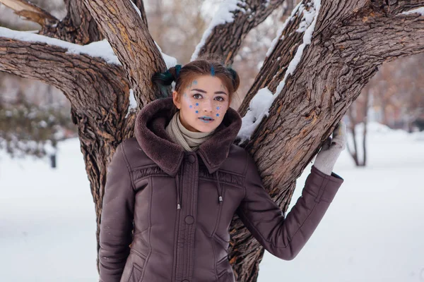 Retrato de inverno de uma menina com estrelas no rosto — Fotografia de Stock