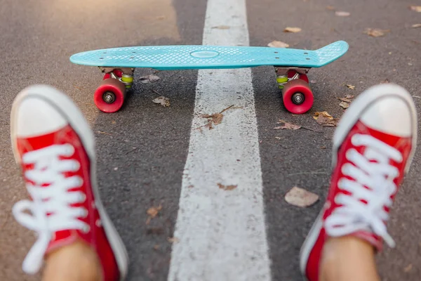 Primo piano di piedi e penny skate board blu con ruote rosa . — Foto Stock