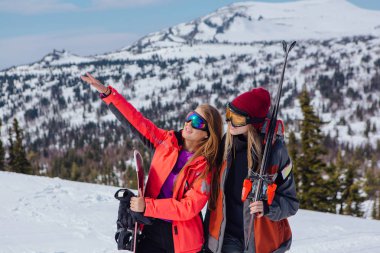 Kayak ve snowboard olan iki genç kadın