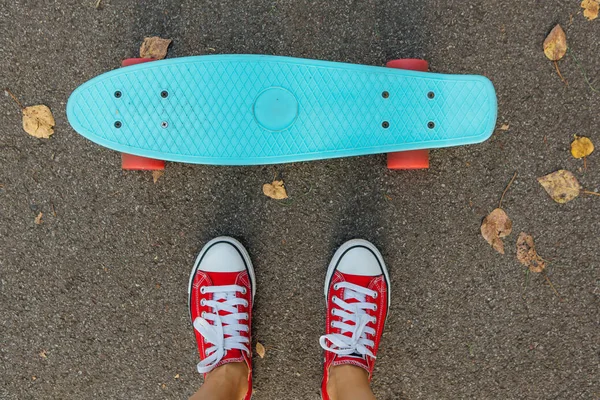 Primo piano di piedi e penny skate board blu con ruote rosa . — Foto Stock