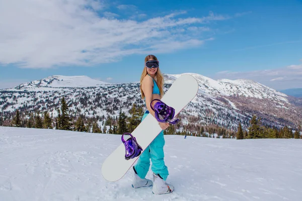 Νεαρή γυναίκα με μαγιό με snowboard στην πλαγιά — Φωτογραφία Αρχείου