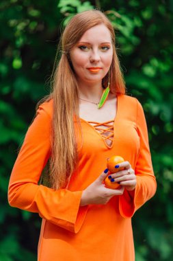Yaz yeşil park sulu lezzetli mandalina ile oldukça Kızıl saçlı kadın portresi.