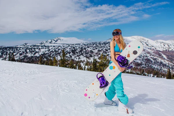 Mujer joven en traje de baño con snowboard en la pendiente — Foto de Stock