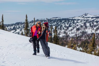 Kayak ve snowboard olan iki genç kadın