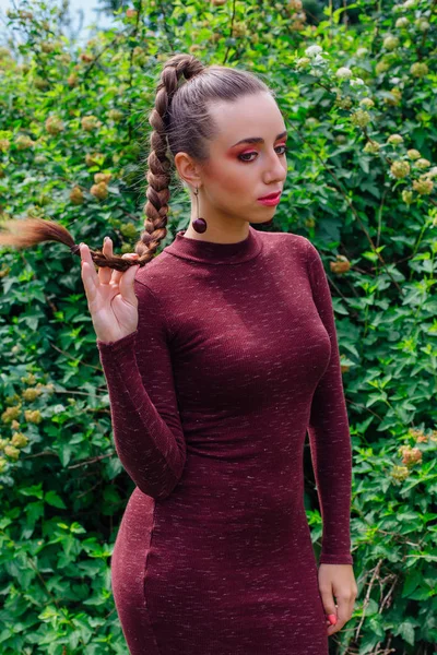 Красива молода жінка з довгою косою і натуральними вишневими сережками . — стокове фото