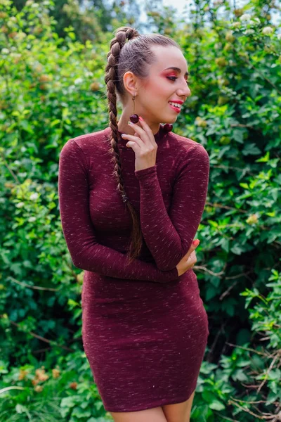 Vacker ung kvinna med lång fläta och naturliga cherry örhängen. — Stockfoto