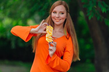 Sulu lezzetli turuncu yaz yeşil park adlı tutan güzel kızıl saçlı kadın portresi.