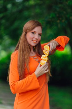 Sulu lezzetli turuncu yaz yeşil park adlı tutan güzel kızıl saçlı kadın portresi.