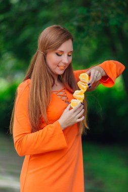 Sulu lezzetli turuncu yaz yeşil park adlı tutan güzel kızıl saçlı kadın portresi.