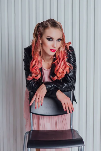 Hermosa joven con pelo rosa en chaqueta de cuero posando en el estudio . — Foto de Stock