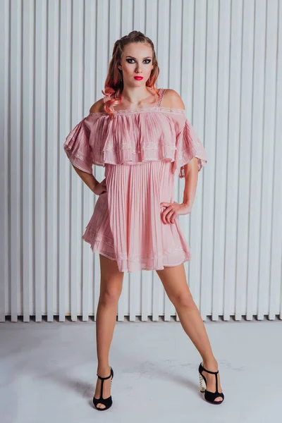 Hermosa joven con el pelo rosa y vestido posando en el estudio . — Foto de Stock