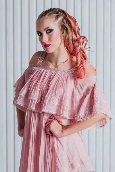 Hermosa joven con el pelo rosa y vestido posando en el estudio . — Foto de Stock