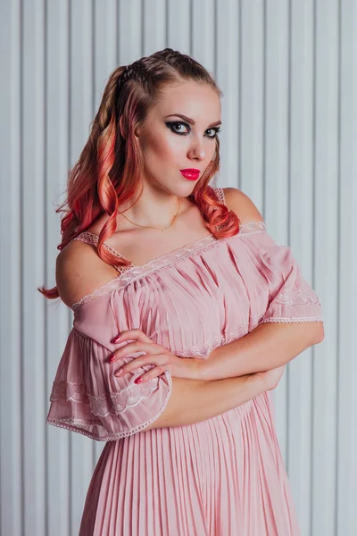 Hermosa joven con el pelo rosa y vestido posando en el estudio . — Foto de Stock