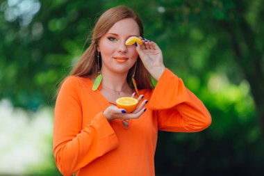 Sulu lezzetli turuncu yaz yeşil park ile oldukça Kızıl saçlı kadın portresi.