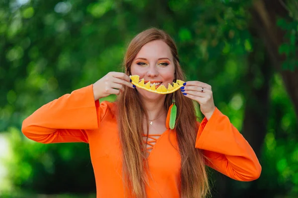 Portrait of pretty red hair woman with juicy delicious orange at summer green park. — Stock Photo, Image