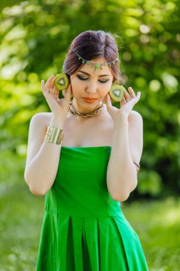 Kivi iki yarısı tutan güzel bir genç Asyalı kadın portresi