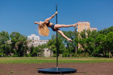 Taşınabilir pole yaz gününde sahada dans uygun çekici kız
