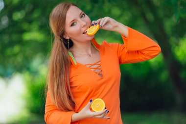 Sulu lezzetli turuncu yaz yeşil park ile oldukça Kızıl saçlı kadın portresi.