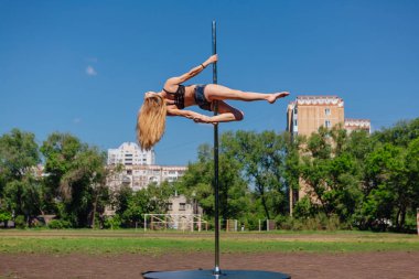Taşınabilir pole yaz gününde sahada dans uygun çekici kız
