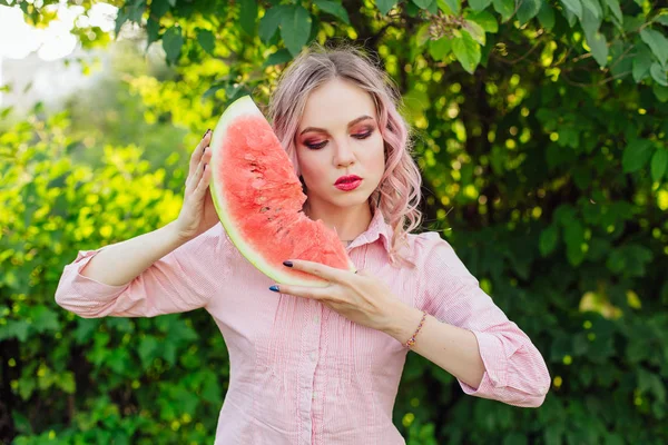 Beautiful young woman with pink hair enjoying watermelon — Stock Photo, Image