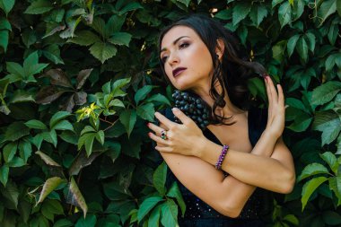 Genç seksi esmer siyah üzüm ile portresi. Kopya alanı.