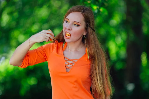 Ritratto di bella donna dai capelli rossi con succosa deliziosa arancia al parco verde estivo . — Foto Stock