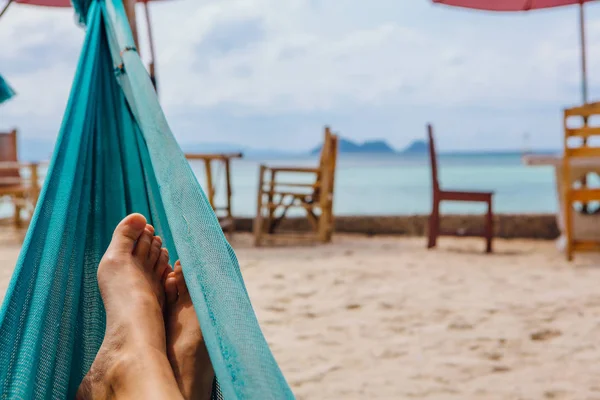 Ноги молодой женщины в гамаке на пляже. Копировальное пространство . — стоковое фото