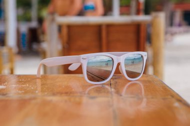 Masanın üzerinde yatan yansıması ile beyaz güneş gözlüğü