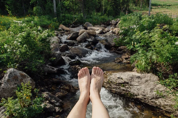 Womans feet infront of the wild mountain river. — Stock Photo, Image