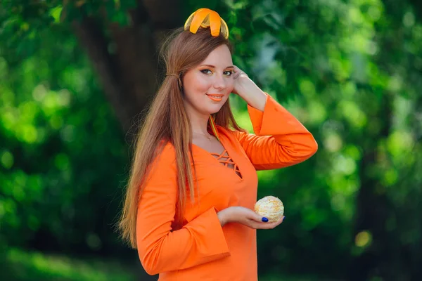 Portret van vrij rood haar vrouw met sappige heerlijke oranje in zomer groen park. — Stockfoto