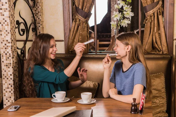 Две счастливые женщины с сахаром в кафе — стоковое фото
