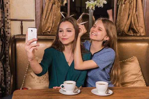 Two beautiful women taking selfie in cafe — Stock Photo, Image