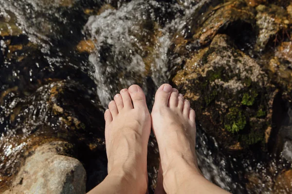 Pies de mujer frente al río salvaje de montaña . —  Fotos de Stock