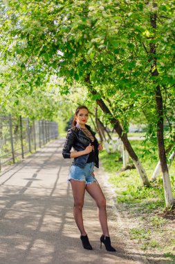 Sevimli kadın yolda bekleyen bir deri ceket giymiş