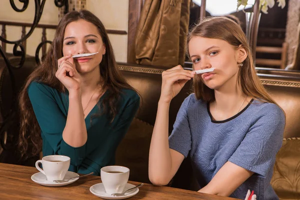 咖啡馆里有两个快乐的女人 plaing 糖 — 图库照片