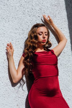 Uzun kırmızı gece elbisesi ayakta duvar eski yanında güzel genç kadın