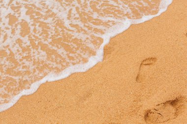 Tropik ada ve ayak beyaz köpük mavi deniz kum üzerine yazdırır