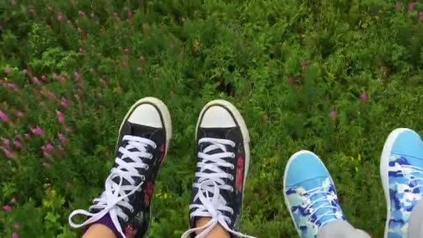 Two pairs feet in sneakers moving on mountain ski lift at summer time — Stock Video