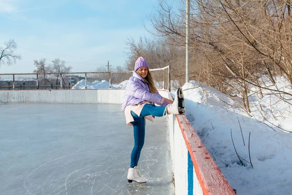 Schöne junge Frau auf Schlittschuhen auf der Eisbahn. — Stockfoto