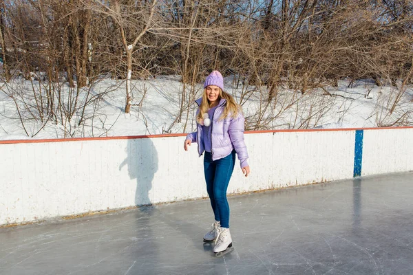 Belle jeune femme chevauchant des patins sur la patinoire . — Photo