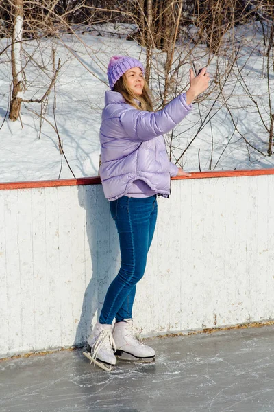 Lovely young woman riding ice skates on the ice rink. — Stock Photo, Image