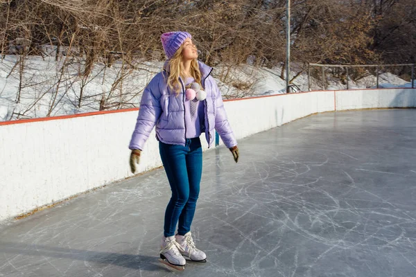 Adorável jovem mulher montando patins de gelo na pista de gelo . — Fotografia de Stock